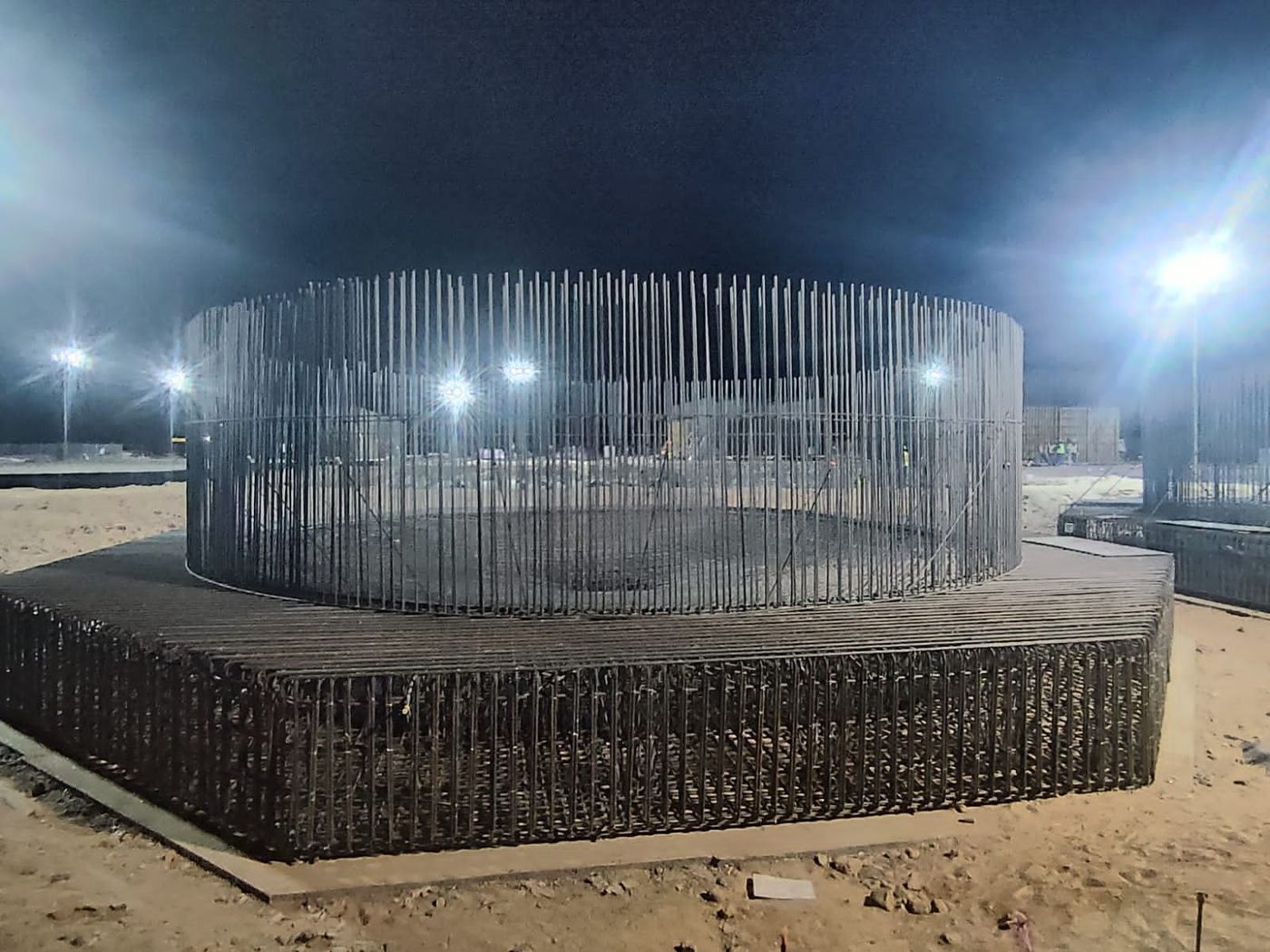 Thickener tank reinforcement cage under floodlights at night